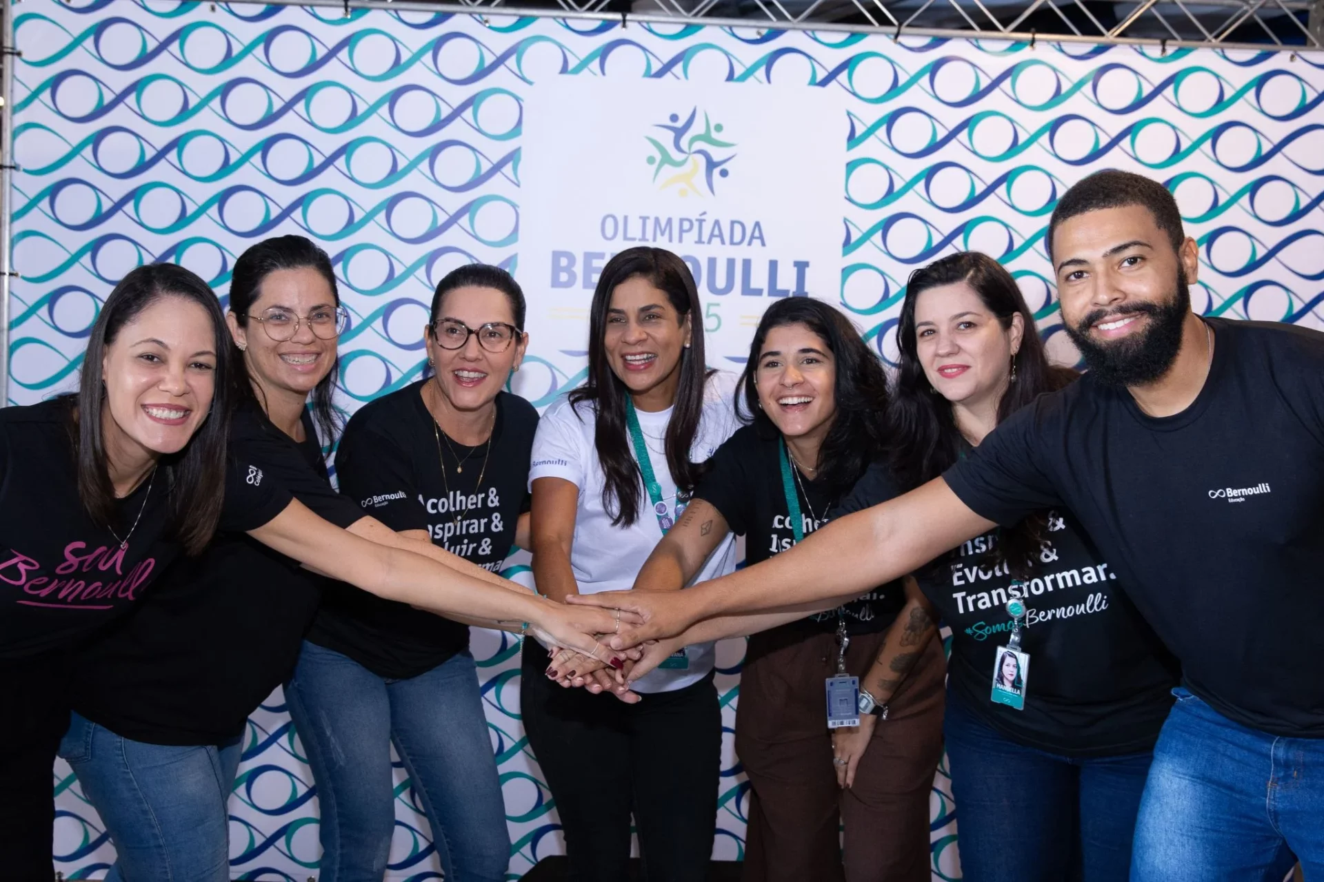 Funcionários do Bernoulli Educação dando as mãos, celebrando