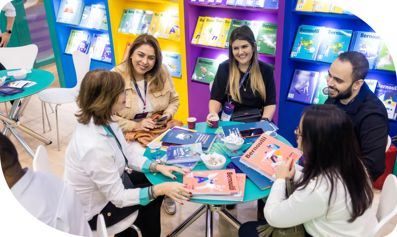 Foto de um grupo de educadores discutindo sobre os livros didáticos do Bernoulli