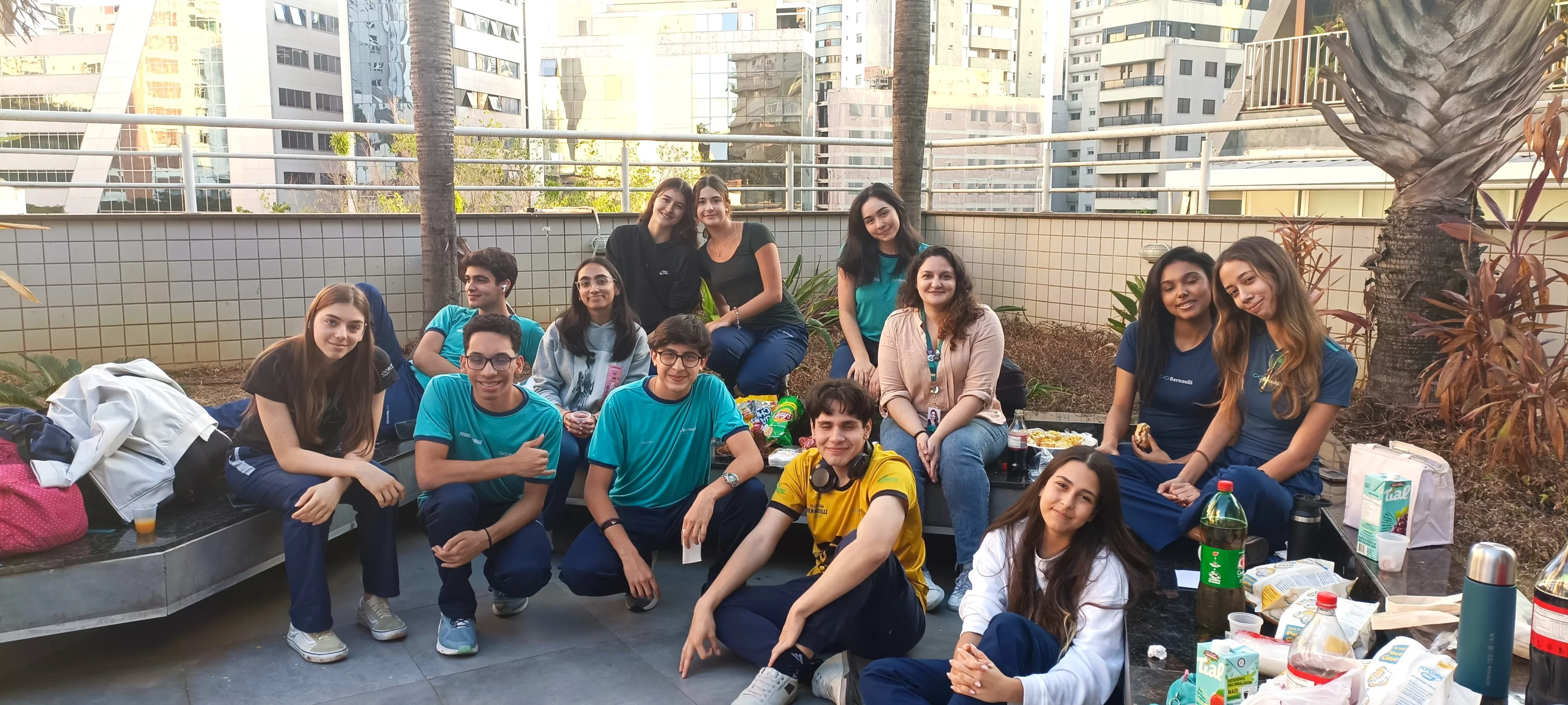 Grupo de alunos e professora confraternizando no pátio da escola