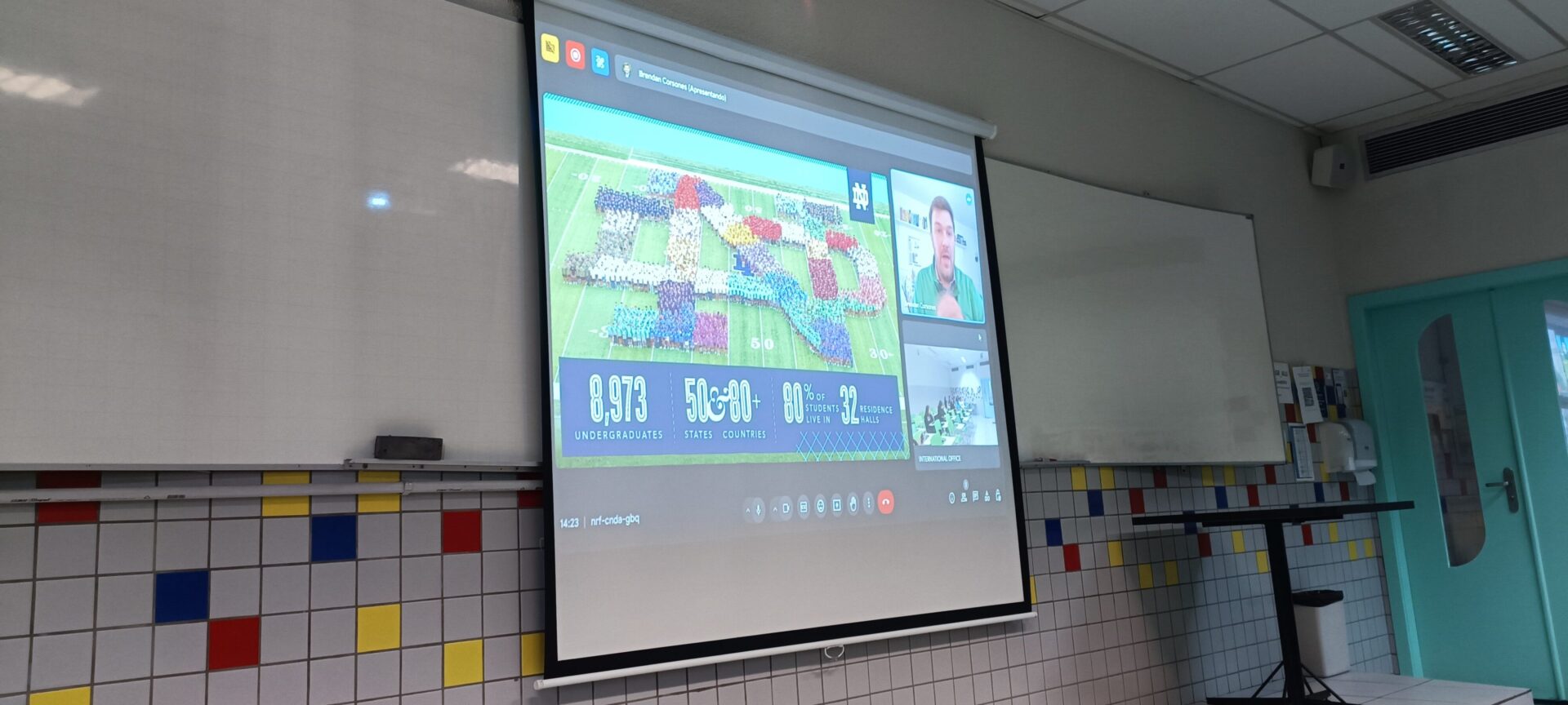 Projetor mostrando uma reunião feita pela internet com a imagem de uma liderança de torcida em destaque