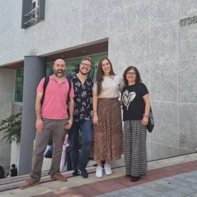 Pessoas pousando em frente a sede do programa escritório internacional